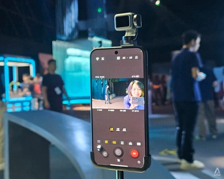 Honor Robot Phone from the front with the gimbal raised over the display and YOYO's blue-eye interface on screen